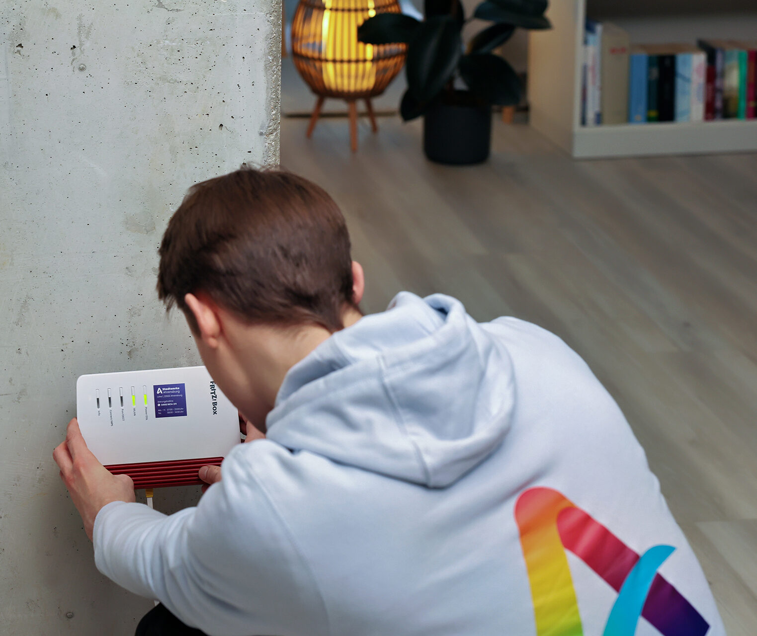 Techniker der Stadtwerke Ahrensburg installiert Glasfaser-Router für schnelles Internet in Ahrensburg