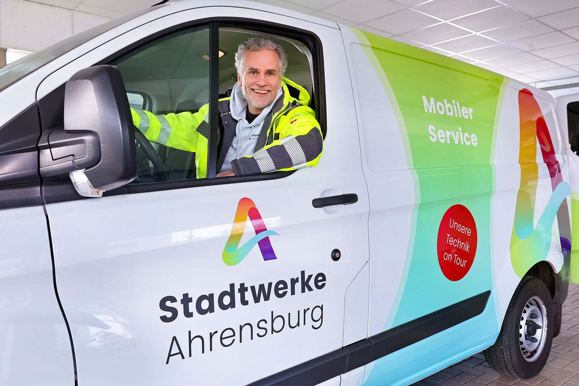 Stadtwerke Ahrensburg – Servicemitarbeiter im mobilen Einsatzfahrzeug mit Firmenlogo und Slogan ‚Unsere Technik on Tour