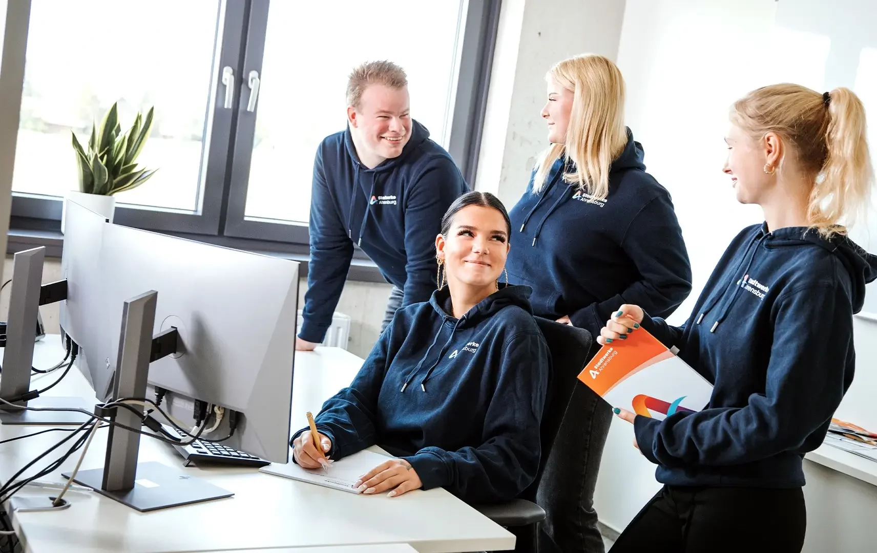 Unsere Azubis vor dem Schreibtisch
