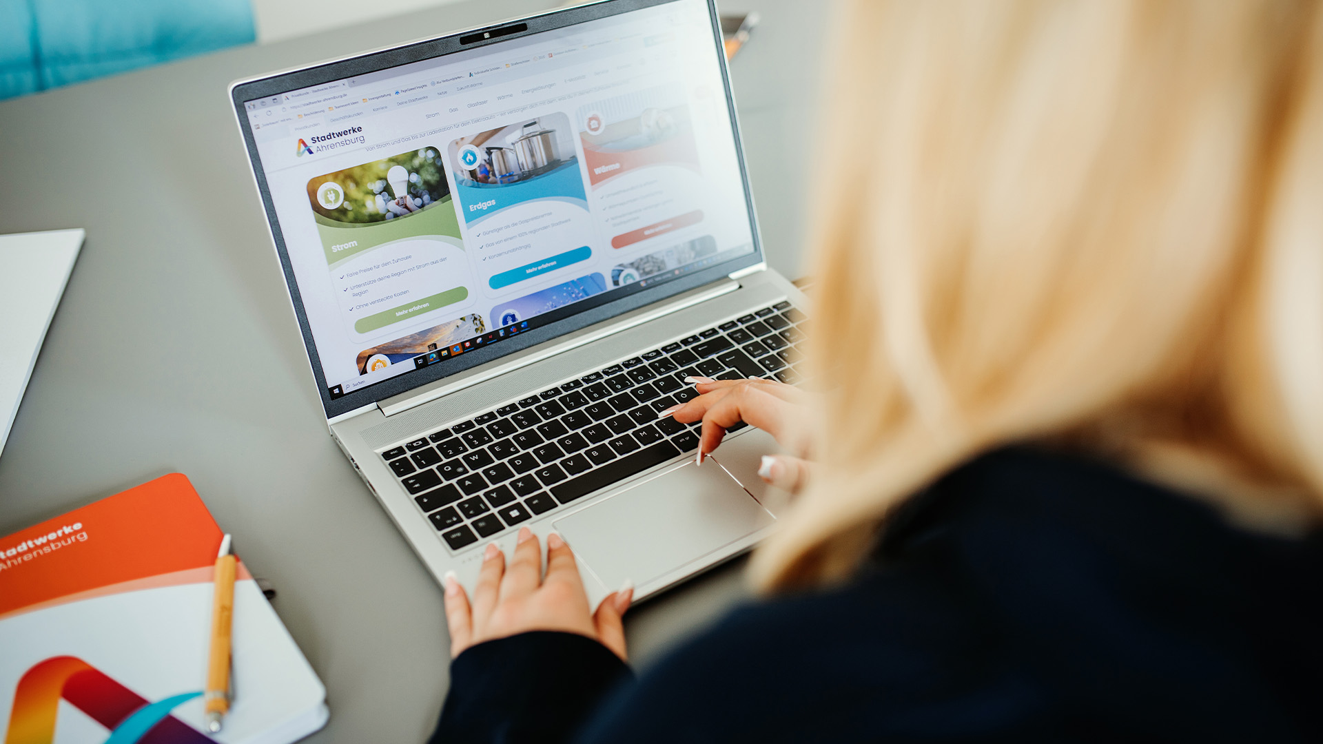 Azubi sitzt vor dem Laptop und surft auf der Stadtwerke Ahrensburg Website